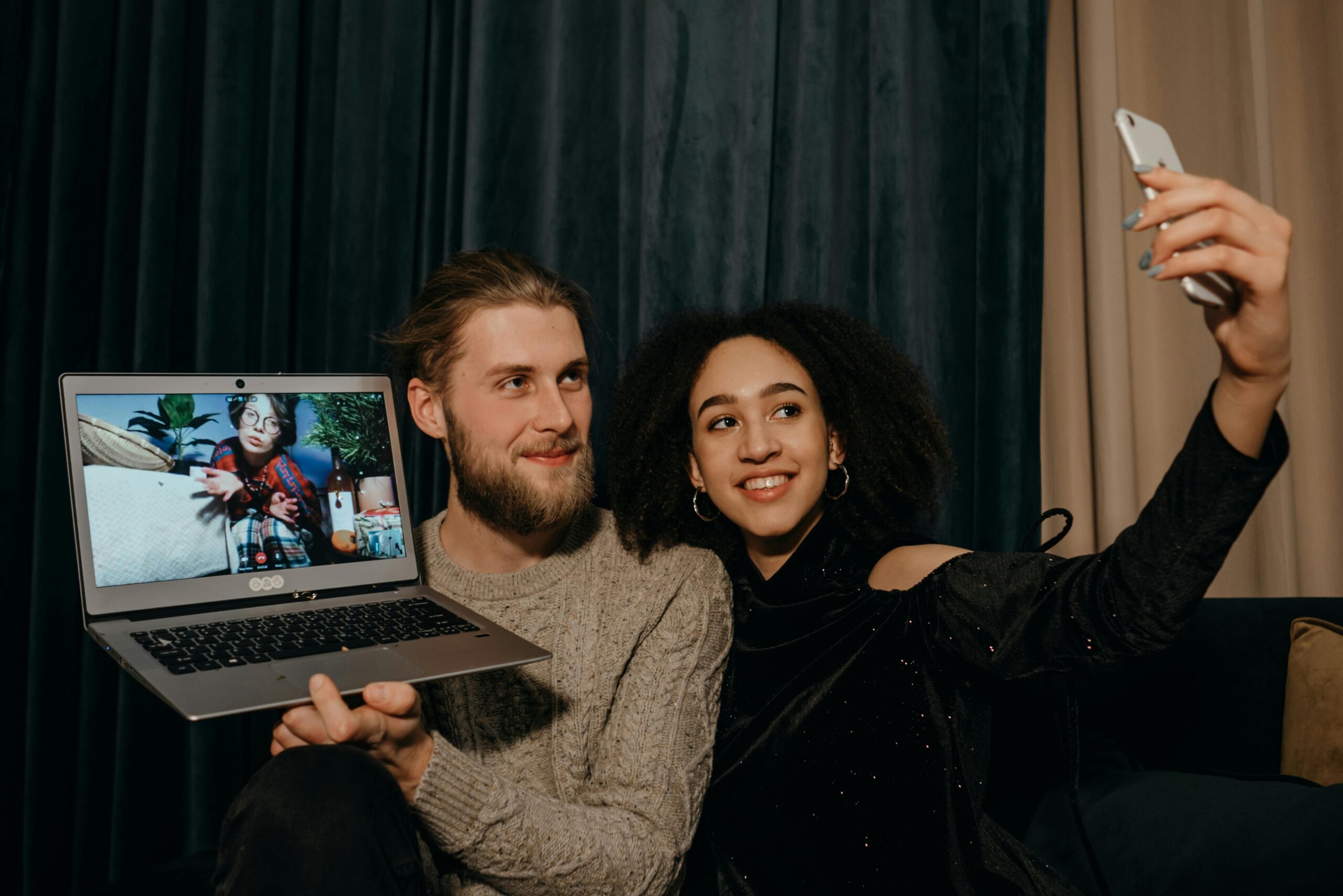 Colleagues taking a selfie during a video call with a new hire on a laptop screen